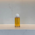 Glass bottle with a white cap on a light gray marble surface